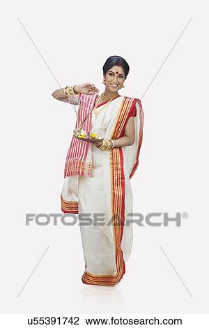 Stock Image - Bengali woman with puja thali smiling. Fotosearch