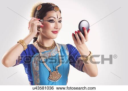Bharatanatyam dancer applying mascara over white background View Large Photo Image Stock Photograph - Bharatanatyam dancer applying mascara over white background. Fotosearch