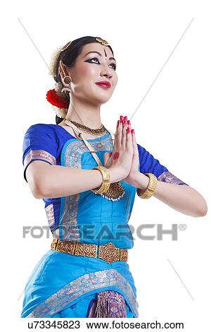 Stock Image - Bharatanatyam dancer in prayer position against white background. Fotosearch