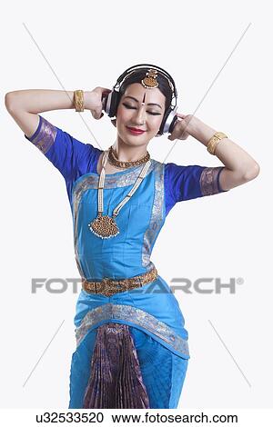 Bharatanatyam dancer listening music on headphones over white background View Large Photo Image Stock Image - Bharatanatyam dancer listening music on headphones over white background. Fotosearch
