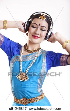 Bharatanatyam dancer listening music through headphones over white background View Large Photo Image Stock Photo - Bharatanatyam dancer listening music through headphones over white background. Fotosearch