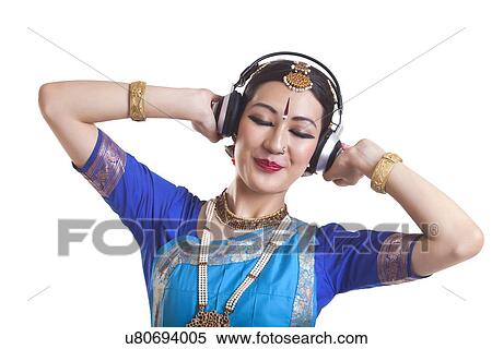 Bharatanatyam dancer listening music through headphones over white background View Large Photo Image Stock Photography - Bharatanatyam dancer listening music through headphones over white background. Fotosearch