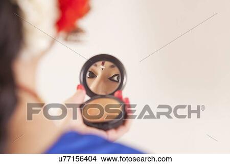 Bharatanatyam dancer looking in hand mirror over white background View Large Photo Image Picture - Bharatanatyam dancer looking in hand mirror over white background. Fotosearch