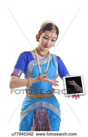 Bharatanatyam dancer showing Kangula Hasta mudra on digital tablet over white background View Large Photo Image Stock Image - Bharatanatyam dancer showing Kangula Hasta mudra on digital tablet over white background. Fotosearch