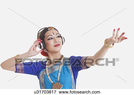 Bharatanatyam dancer wearing headphones while performing over white background View Large Photo Image Stock Photo - Bharatanatyam dancer wearing headphones while performing over white background. Fotosearch