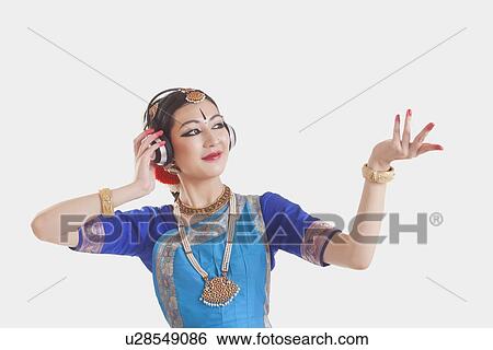 Bharatanatyam dancer wearing headphones while performing over white background View Large Photo Image Stock Photograph - Bharatanatyam dancer wearing headphones while performing over white background. Fotosearch