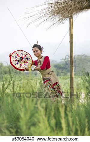 Stock Image - Bihu dancer holding a jaapi . Fotosearch