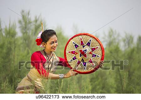 Stock Image - Bihu dancer holding a jaapi . Fotosearch