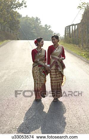 Picture - Bihu dancers holding hands and walking . Fotosearch