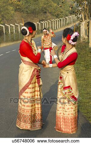 Stock Photograph - Bihu dancers look on as a Bihu man waves to them . Fotosearch