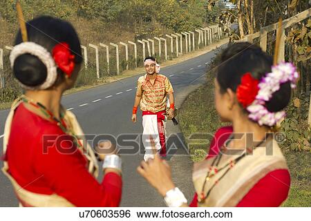 Stock Photograph - Bihu dancers look on as a Bihu man walks up to them . Fotosearch