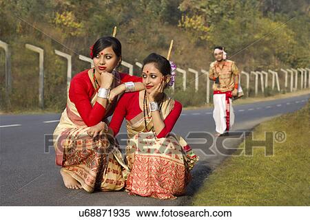 Stock Photography - Bihu dancers squatting as Bihu man walks up . Fotosearch