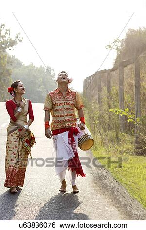 Stock Photograph - Bihu dancers walking together and laughing . Fotosearch