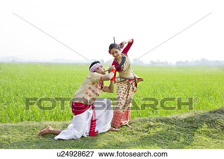 Stock Photo - Bihu man blowing on a pepa while Bihu woman dances to his tune . Fotosearch