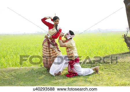 Stock Photo - Bihu man blowing on a pepa while Bihu woman dances to his tune . Fotosearch