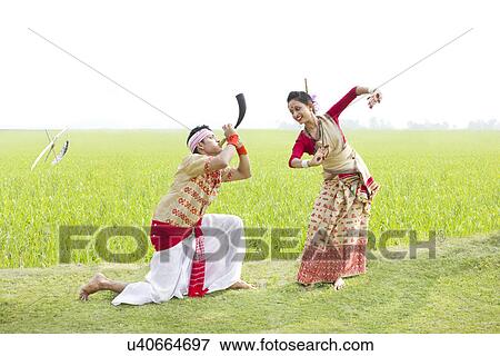 Stock Photo - Bihu man blowing on a pepa while Bihu woman dances to his tune . Fotosearch