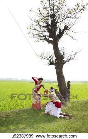Bihu man blowing on a pepa while Bihu woman dances to his tune View Large Photo Image Stock Photo - Bihu man blowing on a pepa while Bihu woman dances to his tune . Fotosearch