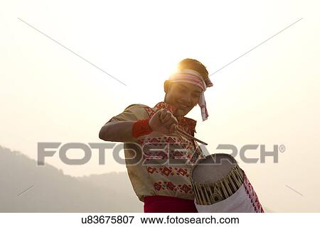 Stock Photo - Bihu man playing on a dhol . Fotosearch