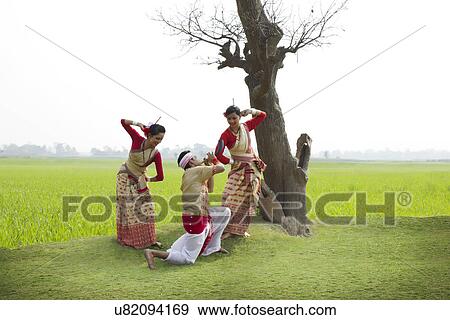 Bihu man playing on a pepa while Bihu women dance to his tune View Large Photo Image Stock Photo - Bihu man playing on a pepa while Bihu women dance to his tune . Fotosearch
