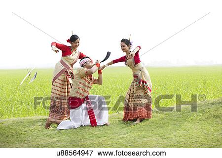 Stock Photo - Bihu man playing on a pepa while Bihu women dance to his tune . Fotosearch