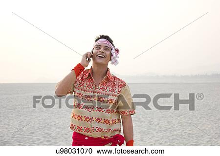 Bihu man talking on a mobile phone View Large Photo Image Stock Image - Bihu man talking on a mobile phone . Fotosearch