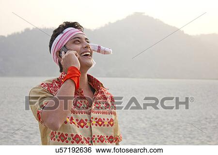 Bihu man talking on a mobile phone View Large Photo Image Stock Photograph - Bihu man talking on a mobile phone . Fotosearch