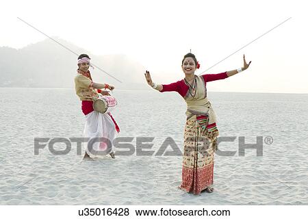 Bihu woman dancing as Bihu man plays on a dhol View Large Photo Image Stock Photo - Bihu woman dancing as Bihu man plays on a dhol . Fotosearch