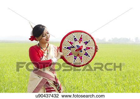 Stock Image - Bihu woman holding a jaapi . Fotosearch