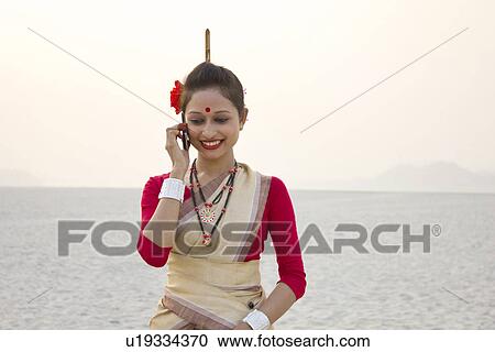 Bihu woman talking on a mobile phone View Large Photo Image Stock Image - Bihu woman talking on a mobile phone . Fotosearch