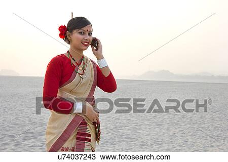 Stock Image - Bihu woman talking on a mobile phone . Fotosearch