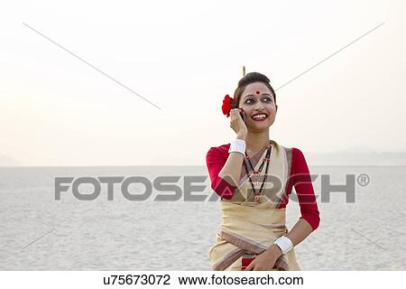 Stock Image - Bihu woman talking on a mobile phone . Fotosearch