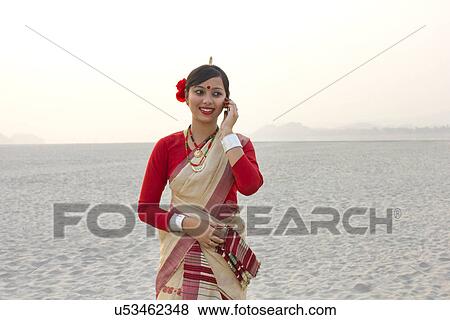 Stock Photo - Bihu woman talking on a mobile phone . Fotosearch