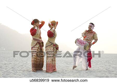 Stock Photo - Bihu women dancing as Bihu man plays on a dhol . Fotosearch