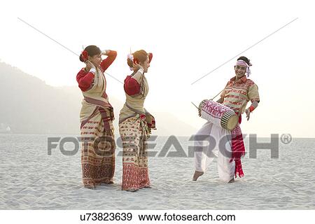 Stock Photo - Bihu women dancing as Bihu man plays on a dhol . Fotosearch