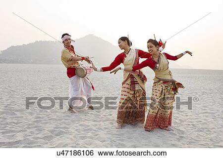 Bihu women dancing as Bihu man plays on a dhol View Large Photo Image Stock Photograph - Bihu women dancing as Bihu man plays on a dhol . Fotosearch