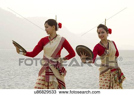 Stock Image - Bihu women dancing with brass plates . Fotosearch