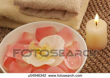 Stock Image - Bowl with orchid and rose petals . Fotosearch
