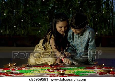 Boy and girl making a rangoli View Large Photo Image Stock Image - Boy and girl making a rangoli . Fotosearch