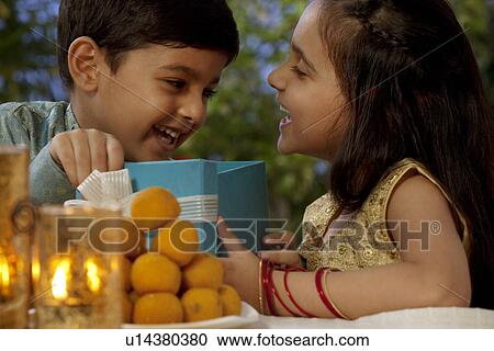 Boy and girl opening gifts on Diwali View Large Photo Image Stock Image - Boy and girl opening gifts on Diwali . Fotosearch
