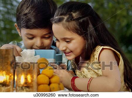 Boy and girl opening gifts on Diwali View Large Photo Image Stock Image - Boy and girl opening gifts on Diwali . Fotosearch