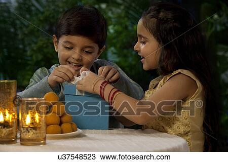 Boy and girl opening gifts on Diwali View Large Photo Image Stock Image - Boy and girl opening gifts on Diwali . Fotosearch