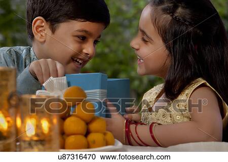 Boy and girl opening gifts on Diwali View Large Photo Image Stock Image - Boy and girl opening gifts on Diwali . Fotosearch