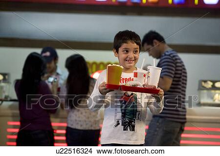 Boy carrying cola and popcorn View Large Photo Image Picture - Boy carrying cola and popcorn . Fotosearch
