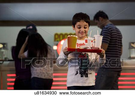 Stock Image - Boy carrying cola and popcorn . Fotosearch