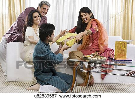 Stock Photo - Boy giving a gift to his sister on Rakhi . Fotosearch
