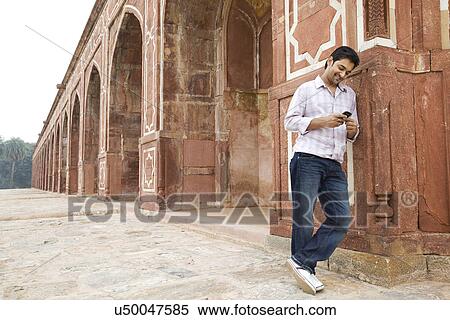 Boy looking at an sms at Humayuns Tomb View Large Photo Image Stock Photography - Boy looking at an sms at Humayuns Tomb . Fotosearch