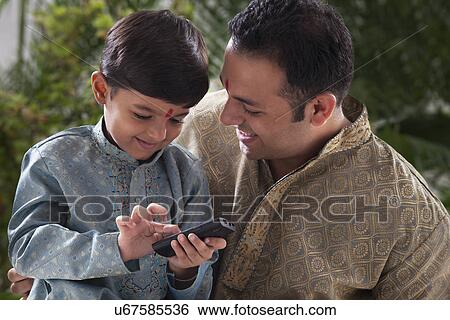 Boy playing with a mobile phone View Large Photo Image Stock Photograph - Boy playing with a mobile phone . Fotosearch