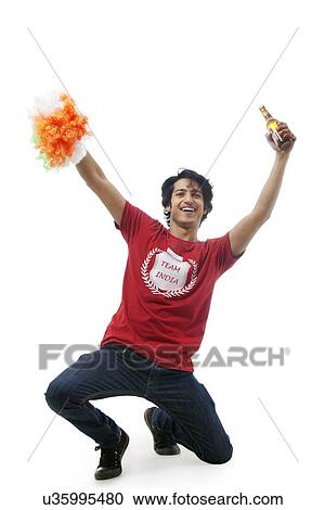 Stock Image - Boy with a beer bottle cheering . Fotosearch