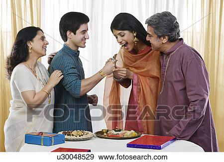 Brother feeding his sister during Rakhi View Large Photo Image Stock Photo - Brother feeding his sister during Rakhi . Fotosearch