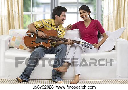 Stock Photo - Brother playing a song for his sister . Fotosearch